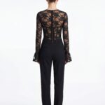 Back shot of black lace corset top paired with tailored black trousers