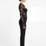 Side profile view of lace corset top with straight-leg black dress pants