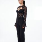 Three-quarter side shot of tie-neck black lace corset trouser outfit