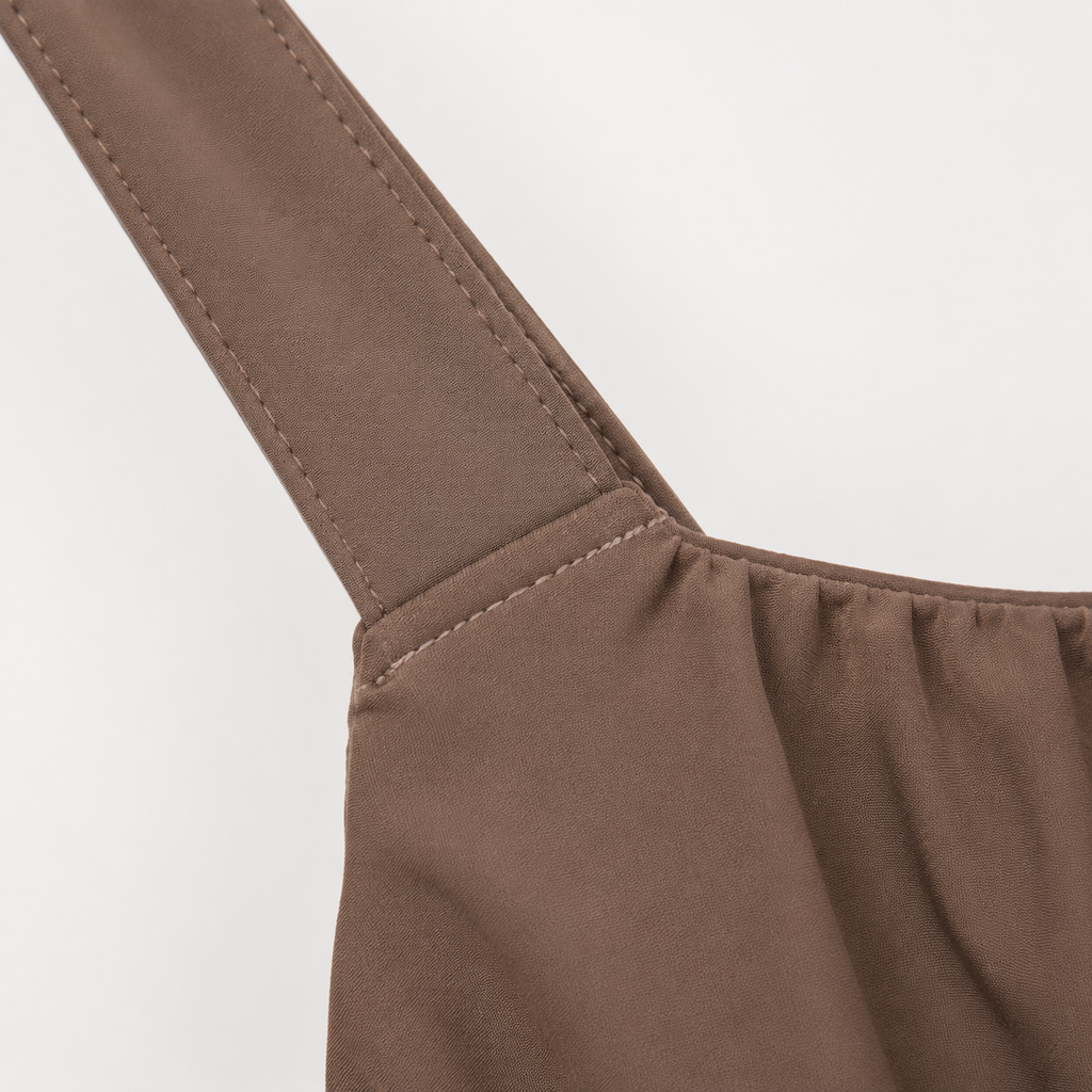 Diagram of one shoulder dress construction highlighting the shoulder strap attachment and side seam, with seam strength specs (120 N per ASTM D1683) and stitch density requirements.
