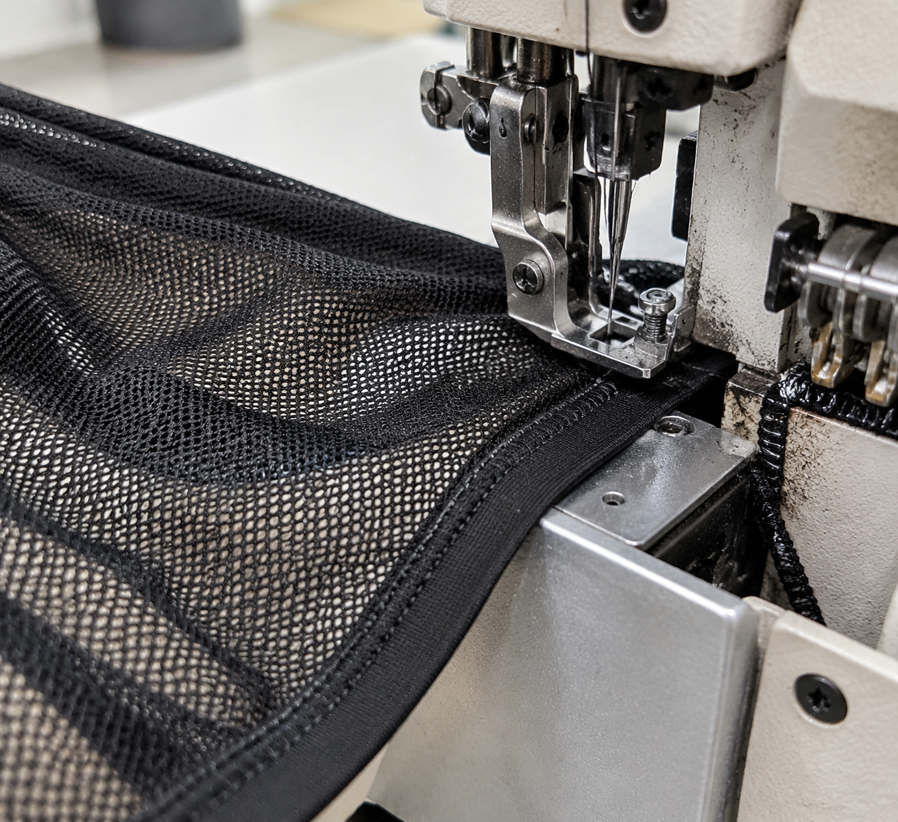 Diagram of five edge-finish methods on a mesh panel — fold-over elastic, binding, clean-finished hem, bonded edge, and sewn band — with needle size and stitch type labeled at each